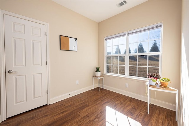 interior space with dark wood-style floors, visible vents, and baseboards