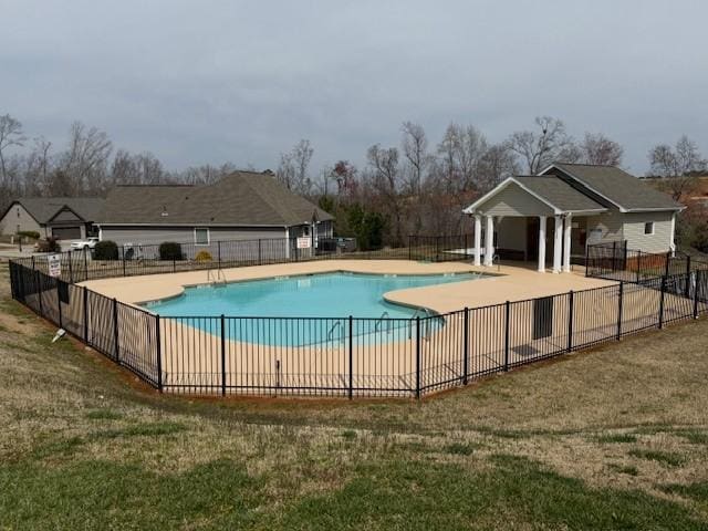 pool with a yard, a patio, and fence