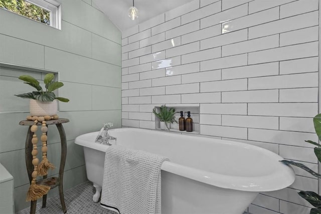 bathroom featuring lofted ceiling, tile walls, and a tub