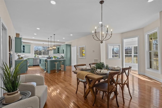 dining area with a notable chandelier and light hardwood / wood-style flooring