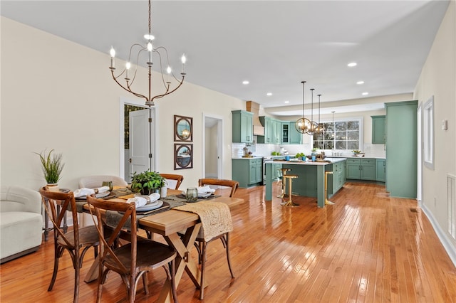 dining room featuring a chandelier, recessed lighting, and light wood-style flooring