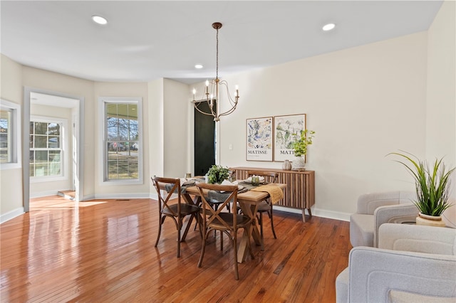 dining area featuring baseboards, recessed lighting, wood finished floors, and an inviting chandelier