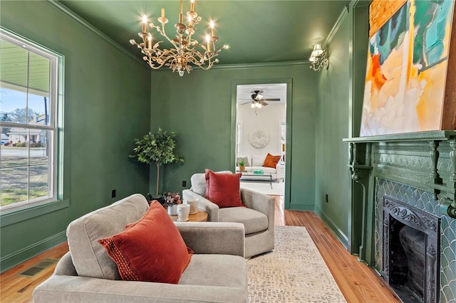 sitting room with a healthy amount of sunlight, visible vents, and crown molding