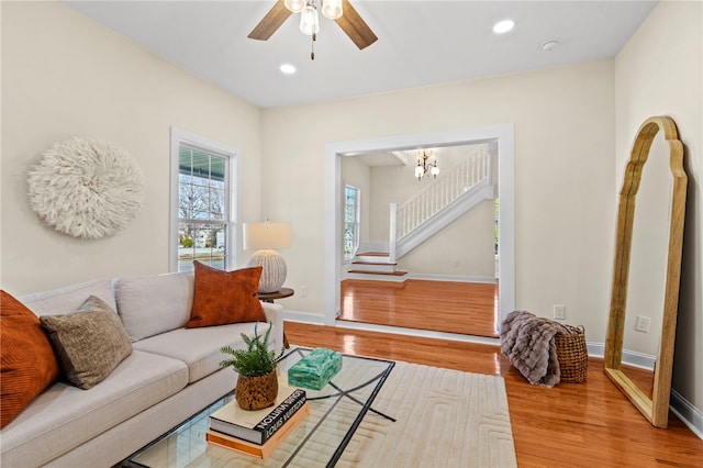 living room featuring baseboards, stairway, recessed lighting, and light wood-style floors