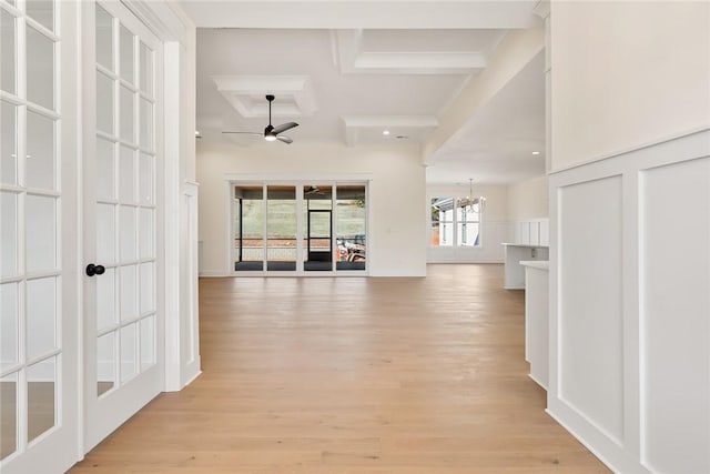 corridor with a notable chandelier, beamed ceiling, coffered ceiling, and light hardwood / wood-style floors