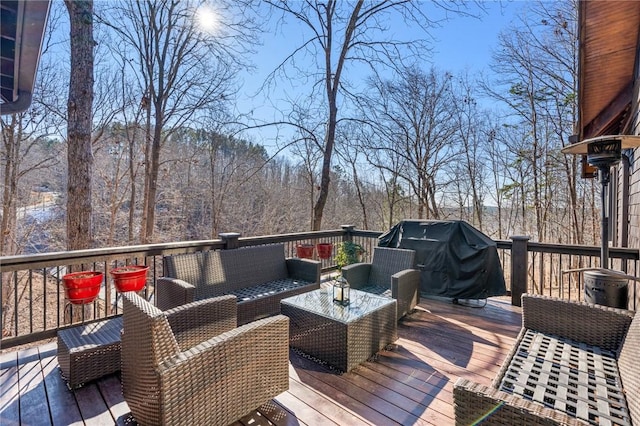 wooden terrace featuring grilling area and an outdoor hangout area