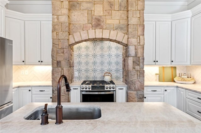 kitchen with white cabinets, appliances with stainless steel finishes, sink, and tasteful backsplash