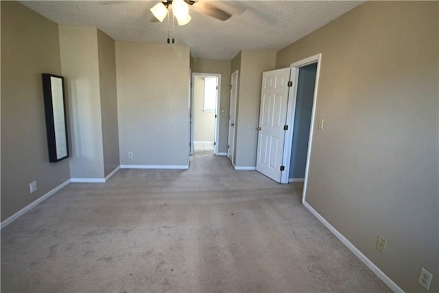 carpeted spare room featuring a textured ceiling and ceiling fan