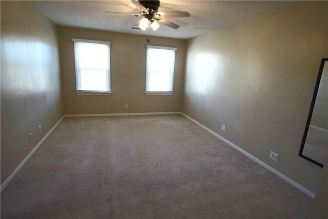 spare room with ceiling fan, light colored carpet, and a textured ceiling