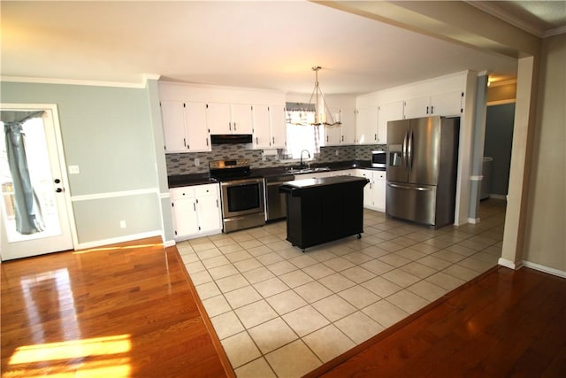 kitchen with sink, pendant lighting, appliances with stainless steel finishes, and white cabinets