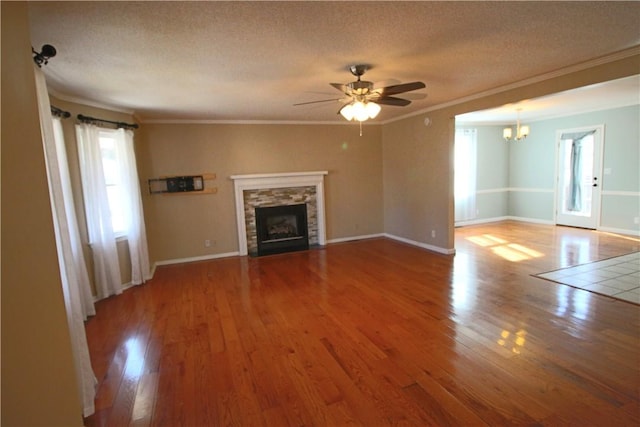 unfurnished living room with ceiling fan with notable chandelier, crown molding, and hardwood / wood-style floors