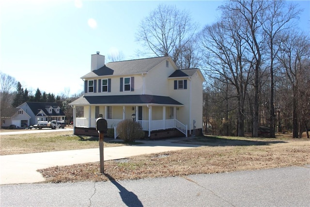 view of front of property featuring covered porch and a front lawn