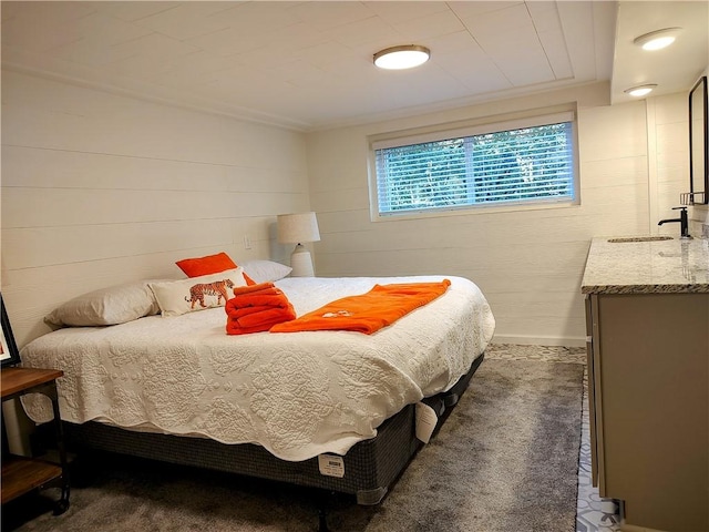 bedroom featuring ornamental molding, sink, and wood walls