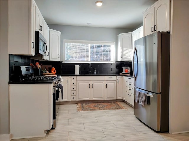 kitchen featuring white cabinetry, appliances with stainless steel finishes, sink, and backsplash