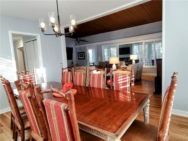 dining area with wood-type flooring and ceiling fan with notable chandelier