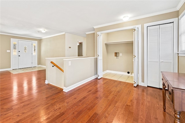 foyer entrance featuring crown molding and light hardwood / wood-style floors