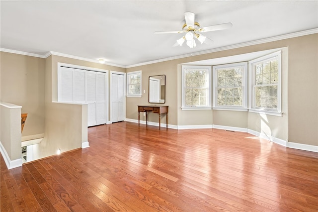 interior space with ceiling fan, ornamental molding, and wood-type flooring