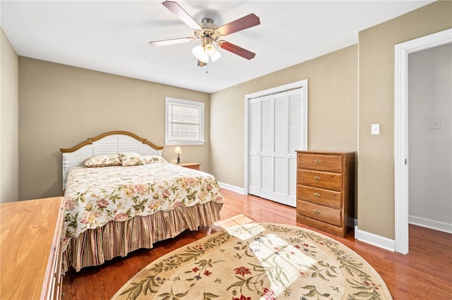 bedroom with ceiling fan, a closet, and hardwood / wood-style flooring