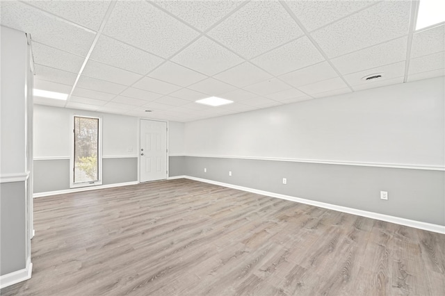 basement with a paneled ceiling and light hardwood / wood-style flooring