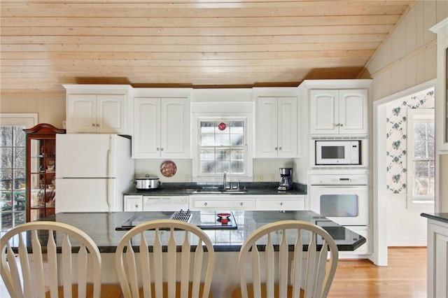 kitchen featuring white appliances, white cabinetry, sink, vaulted ceiling, and wooden ceiling