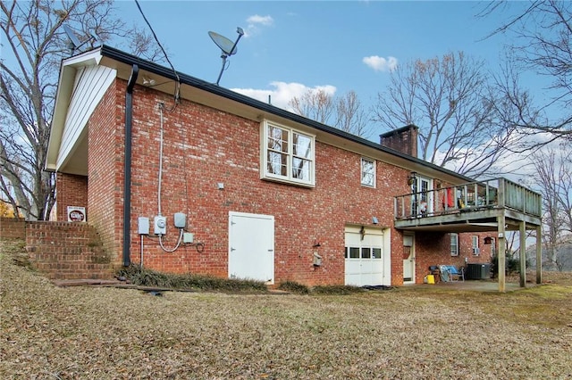 back of property featuring central AC unit, a deck, a yard, and a garage