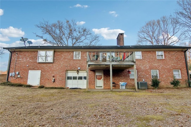 rear view of house featuring a garage, central AC, and a balcony