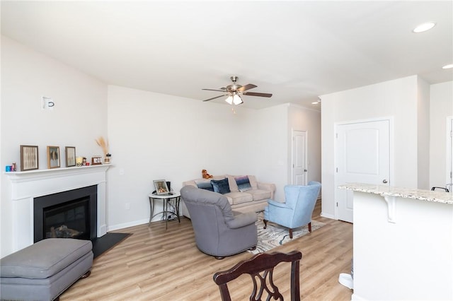 living room with ceiling fan and light hardwood / wood-style flooring