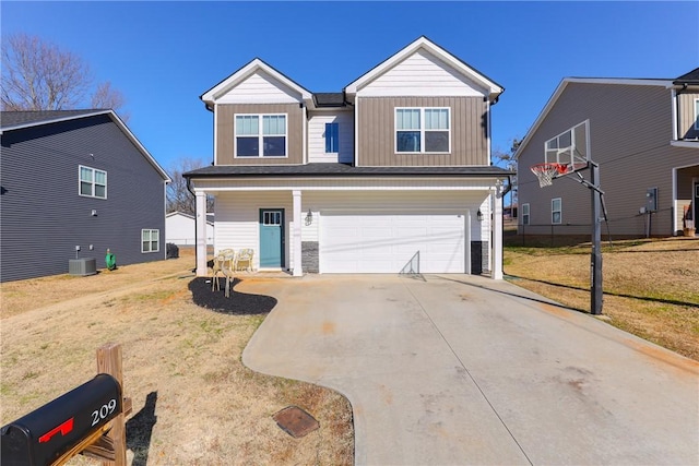 view of front of house with a garage, cooling unit, and a front lawn