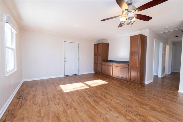 unfurnished living room with ceiling fan, hardwood / wood-style floors, and ornamental molding