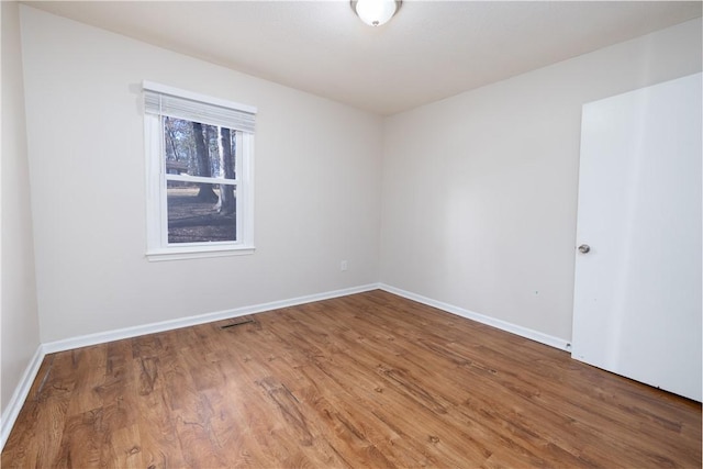 unfurnished room with hardwood / wood-style flooring