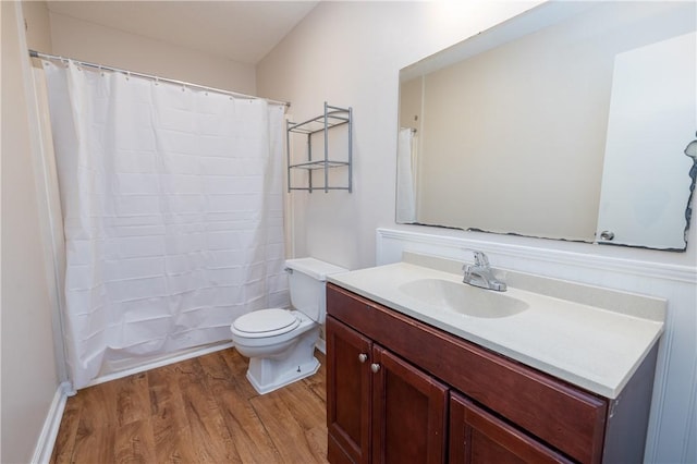 bathroom with toilet, vanity, and hardwood / wood-style floors