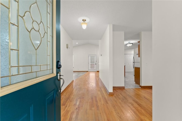 foyer entrance with lofted ceiling and light hardwood / wood-style floors