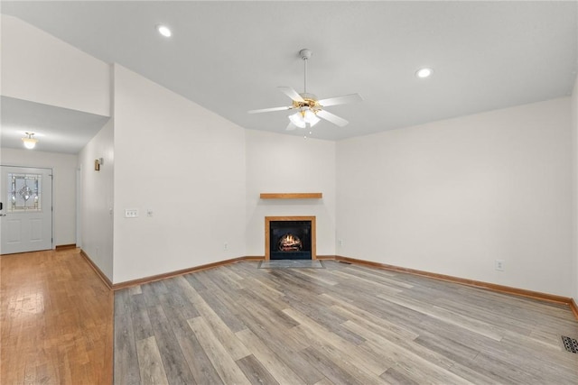 unfurnished living room with ceiling fan and light hardwood / wood-style floors