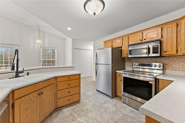 kitchen featuring lofted ceiling, decorative light fixtures, stainless steel appliances, sink, and backsplash