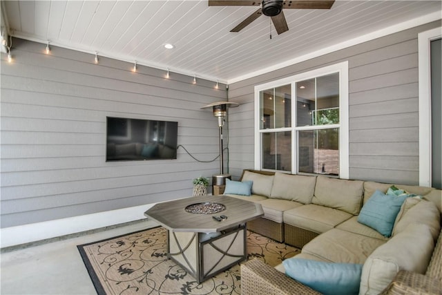 view of patio / terrace with ceiling fan and an outdoor living space with a fire pit