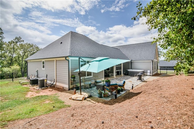 back of house with central AC, a hot tub, and a patio area