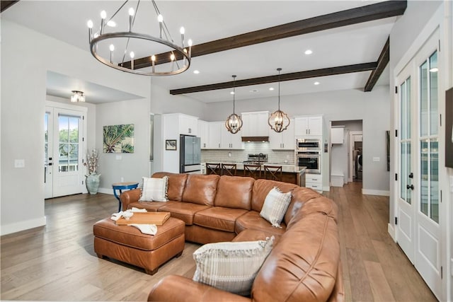 living room featuring beam ceiling, french doors, a notable chandelier, and light hardwood / wood-style floors