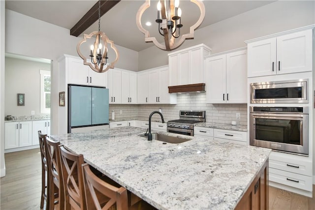 kitchen with a chandelier, white cabinets, and built in appliances