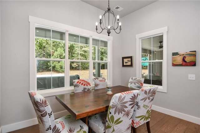 dining room with dark wood-type flooring, a chandelier, and plenty of natural light