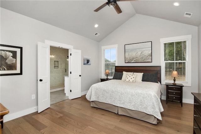 bedroom with ensuite bathroom, lofted ceiling, ceiling fan, and hardwood / wood-style flooring