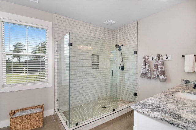 bathroom featuring tile patterned flooring, walk in shower, and vanity