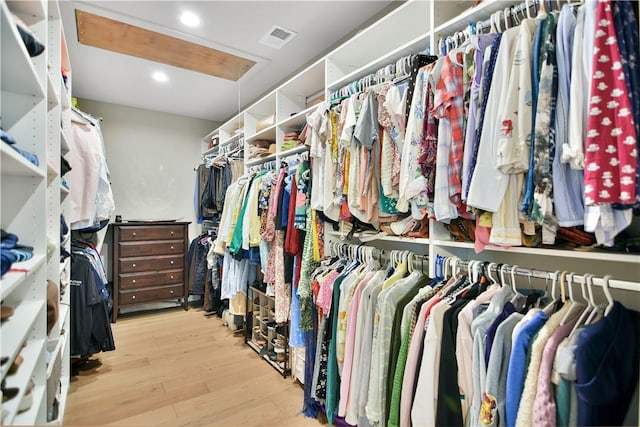 walk in closet with light hardwood / wood-style floors