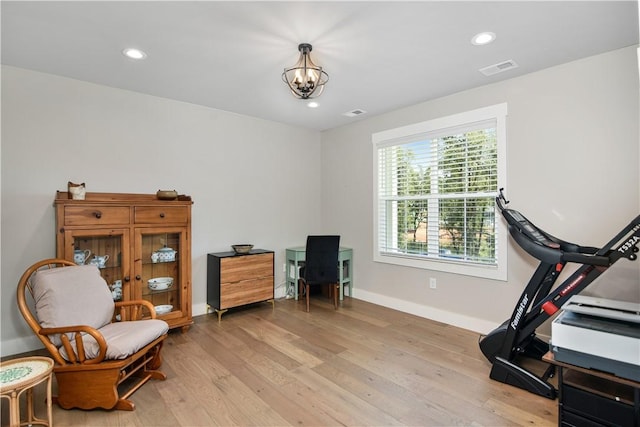 sitting room featuring a chandelier and light wood-type flooring