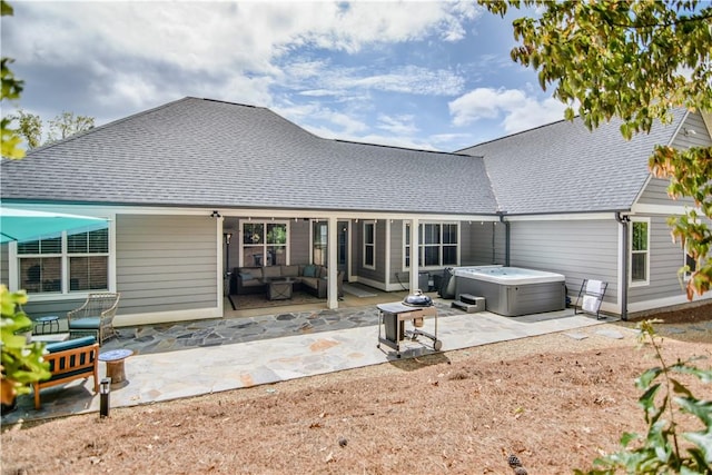 back of property with an outdoor living space, a hot tub, and a patio