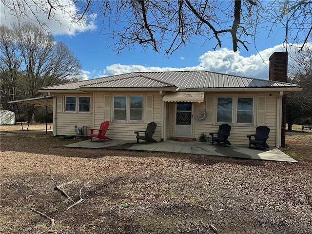 rear view of house with a patio and a carport