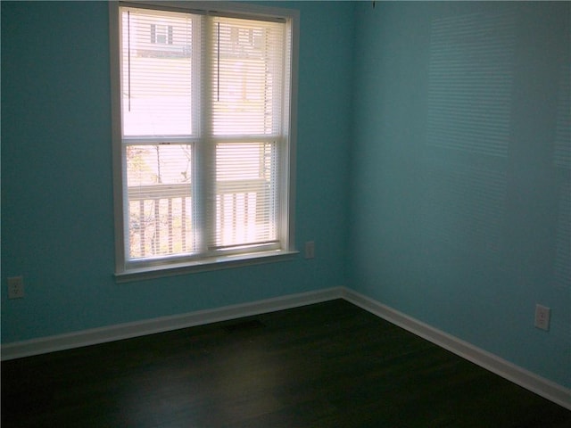 empty room with baseboards and dark wood finished floors