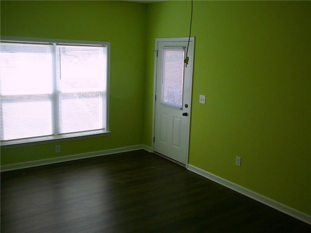 interior space with baseboards, plenty of natural light, and dark wood finished floors