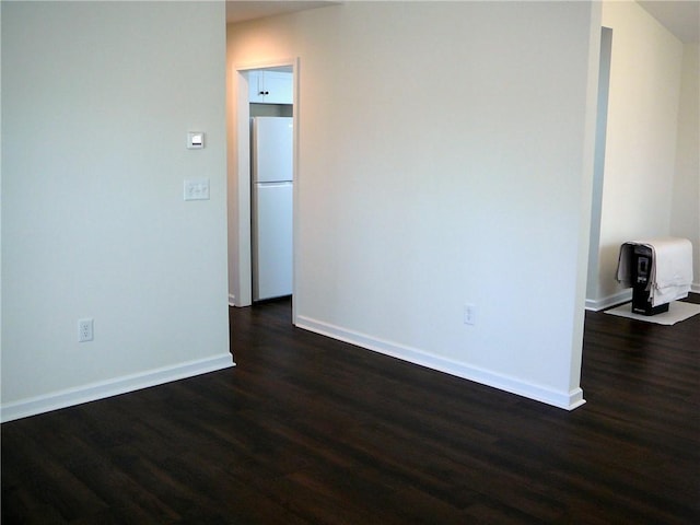 empty room with baseboards and dark wood finished floors