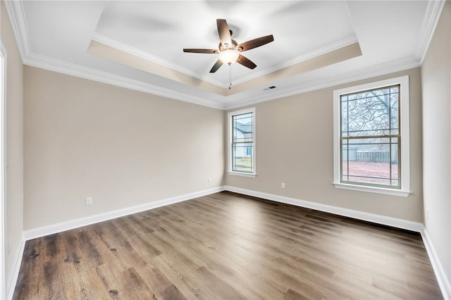 empty room featuring crown molding, ceiling fan, a tray ceiling, and hardwood / wood-style floors