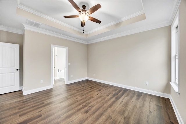 spare room featuring a raised ceiling, ceiling fan, dark hardwood / wood-style floors, and ornamental molding